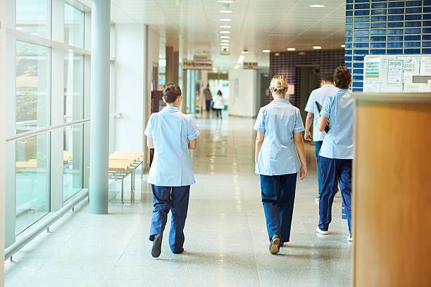 Four members of staff in uniform walking along a bright corridor